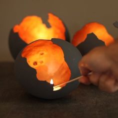 three painted pumpkins sitting on top of a table next to each other with faces drawn on them