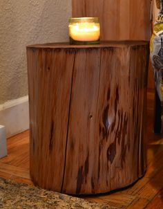 a candle is sitting on top of a tree stump in the middle of a room