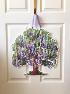 a door hanger with a tree on it and beads hanging from the front part