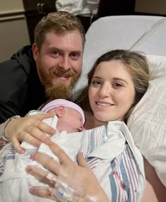 a man and woman holding a baby in a hospital bed