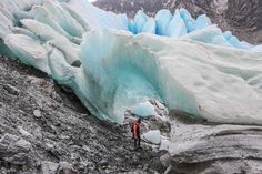 a man standing on the side of a glacier