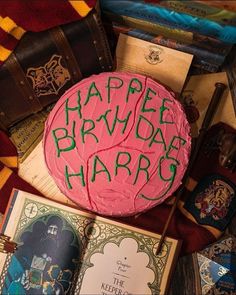 a birthday cake with the words happy birthday harry written on it next to some books