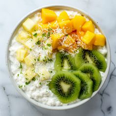 a bowl filled with oatmeal topped with kiwi slices and shredded parmesan cheese