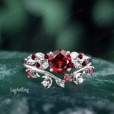 a close up view of a ring with red stones