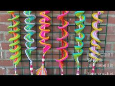 multicolored streamers hanging from a wire rack on a brick wall in front of a building