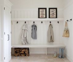 a white bench sitting under two pictures on top of a wooden shelf next to a firewood log