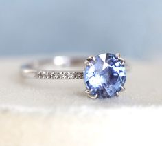 This beautiful ring features 2 - 2.1 ct sparkly blue sapphire. The design can be made with gemstones of your choosing. If you would prefer a custom ring, please contact us before purchase. Details Main stone Gemstone: natural blue sapphire, comes with certificate, ethically sourced 2 - 2.1ct Side stones Gemstone: white diamonds half eternity Quality: clarity grade VS, color grade G, conflict-free Band width: approx 1.8 mm Material: 14/18k solid yellow/white/rose gold, platinum Sizes available: 3 Dazzling Sapphire Ring With Brilliant Cut, Timeless Sapphire Ring With Center Stone As Gift, Gift Moissanite Sapphire Ring With Brilliant Cut, Dazzling Sapphire Diamond Ring With Round Cut, Dazzling Moissanite Sapphire Ring Round Cut, Timeless Round Cut Sapphire Ring, Classic Ethical Sapphire Ring, Dazzling Sapphire Ring With Prong Setting, Dazzling Round Cut Sapphire Ring With Prong Setting