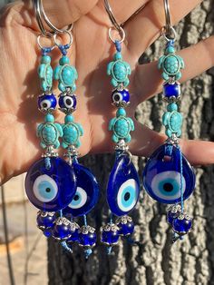 a pair of earrings with evil eyes and beads hanging from it's earwires