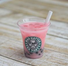 a pink drink in a plastic cup with a straw sticking out of it's top