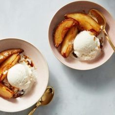 two bowls filled with ice cream and sliced peaches on top of a white table