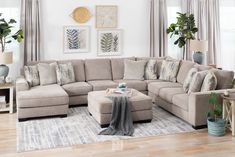 a living room filled with lots of furniture and decor on top of a hard wood floor