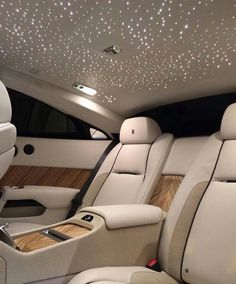 the interior of a luxury car with lights shining on the ceiling and leather upholstered seats