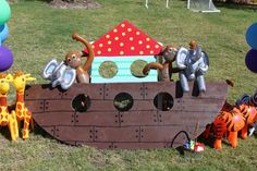 some toys are sitting in the grass near a pirate ship and balloon decorations on display