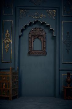 a room with blue walls and gold trimmings on the wall, including an ornate window