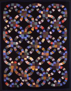 a black quilt with multicolored circles on the front and sides, all in different colors