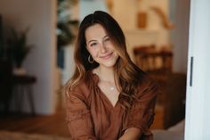 a woman sitting on a bed smiling at the camera