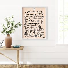 a table with a vase and plant on top of it next to a white wall