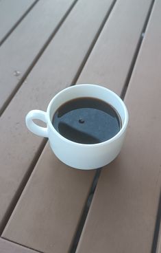 a cup of coffee sitting on top of a wooden table