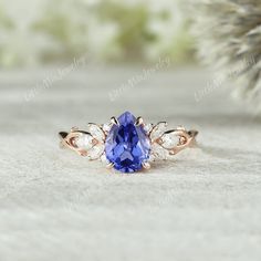 a tan gold ring with a blue stone surrounded by leaves