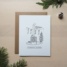 a card with a drawing of a stove and christmas tree on the table next to it