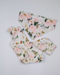 three pieces of cloth with pink flowers on them and one piece is folded up to show the fabric