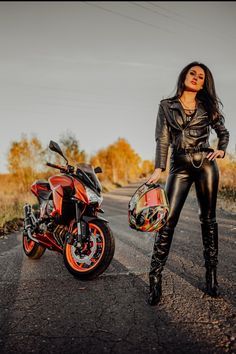 a woman standing next to a motorcycle on the road