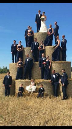 a large group of people standing on hay bales in the middle of a field