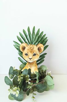 a stuffed lion sitting on top of a lush green leafy plant with white flowers