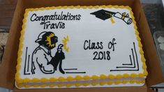 a graduation cake in a box with congratulations travis on it