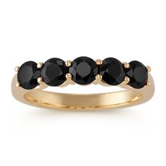 a gold ring with five black stones on top and two rows of diamonds in the middle