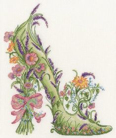 a cross stitched shoe with flowers and vines on the heel, in front of a white background