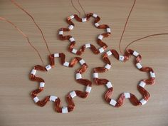 several pieces of copper and white wire are arranged in a circle on a wooden surface