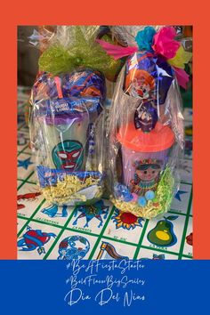 two plastic cups sitting next to each other on top of a tiled floor with colorful decorations