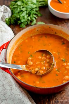 a red pot filled with beans and garnished with parsley