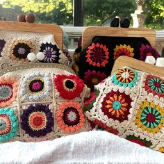 three crocheted purses sitting on top of a bed next to each other