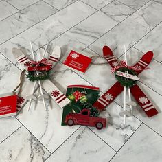 four red and white windmills with christmas decorations on them sitting on a marble floor