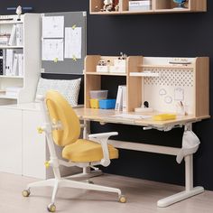 a desk with a yellow chair in front of it and shelves on the wall behind it