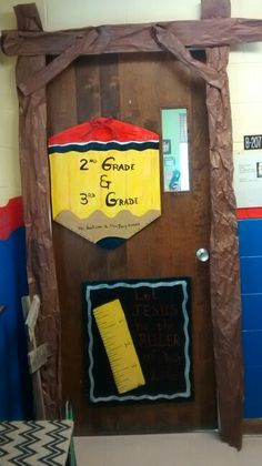 a classroom door decorated to look like a school building with the number 3 and 3rd grade on it