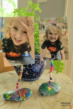 a table with two pictures on it and some beads hanging from the top of them