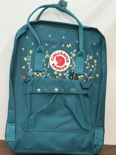 The product you received is an embroidered Kanken backpack The backpack is produced and used in Vietnam market  Actual color may be slightly different due to phone light The package you receive includes backpack and hand-embroidered design as shown. Please read the information carefully to choose the color you want for Version & Size: Version & Size - Kanken No.1: This is the classic (original) version with 3 sizes + Mini size: 29x20x13cm (A5 paper size) + Medium size: 27x38x13cm (laptop 15 inch size) + Large size: 35x45x15cm (laptop 17 inch size) => For the Large size, there are just few color choices so Please look carefully at the color description photo. - Kanken No.2: This is the version with leather straps + Mini size: 29x20x13cm (A5 paper size) + Medium size: 27x38x13cm (laptop 14 i School Backpack With Floral Embroidery, Casual Standard Backpack With Embroidered Logo, Casual Floral Embroidered Backpack, Casual Floral Embroidery Backpack, Floral Embroidery Travel Backpack, Travel Backpack With Embroidered Logo, Casual Backpack With Embroidered Logo For Daily Use, Travel Bags With Embroidered Logo For Back To School, Embroidered Logo Travel Bags For Back To School