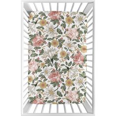 a white crib with pink and yellow flowers on it