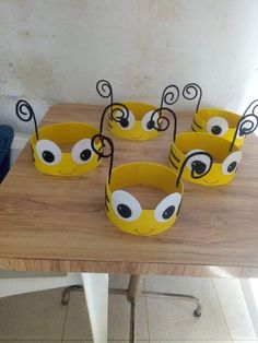 six yellow cups with eyes on them sitting on a table