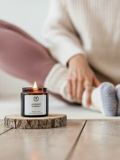 a person sitting on the floor with a candle in front of them