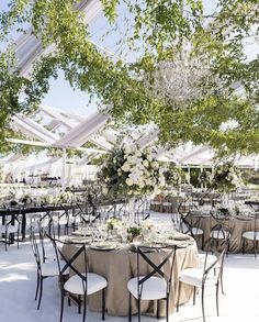 an outdoor event with tables and chairs covered in white linens