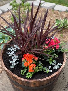 a wooden barrel filled with flowers and plants