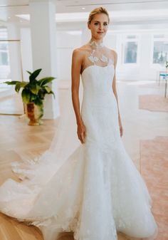 a woman in a wedding dress standing on a wooden floor