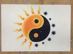 a drawing of a sun and moon with stars in the background on a piece of paper