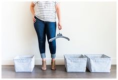 a woman standing in front of three storage bins with an umbrella over her head