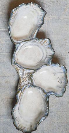 three white seashells sitting on top of a wooden table