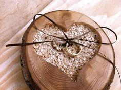 a wooden slice with a ring on it and some wood shavings in the shape of a heart